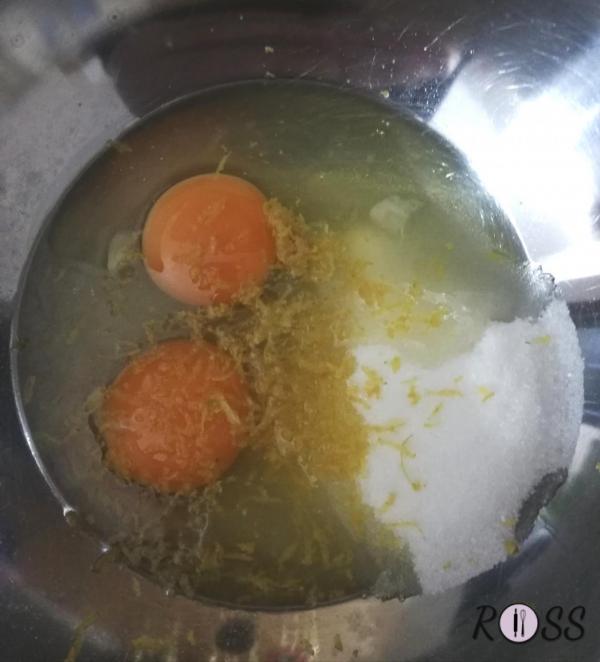 In una ciotola unite le uova allo zucchero semolato e la buccia grattugiata di limone. Mescolare con una frusta elettrica per circa 2 minuti.
