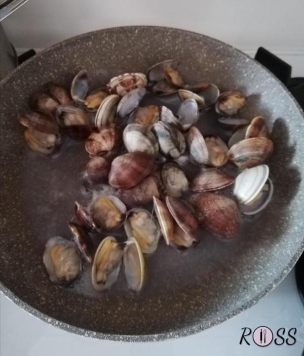 Lavate le vongole sotto l'acqua corrente.
Mettetele in una padella capiente dai bordi alti, coprite e cuocete a fuoco vivace(in questo modo le valve si apriranno).
Spegnete appena tutte le vale si saranno aperte. Adesso sgusciate la maggior parte delle vongole e lasciarne con il guscio una piccola parte da usare come decorazione. 
