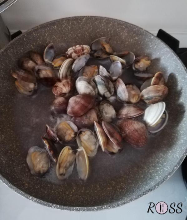 Lavate le vongole sotto l'acqua corrente.
Mettetele in una padella capiente dai bordi alti, coprite e cuocete a fuoco vivace(in questo modo le valve si apriranno).
Spegnete appena tutte le vale si saranno aperte. Adesso sgusciate la maggior parte delle vongole e lasciarne con il guscio una piccola parte da usare come decorazione. 
