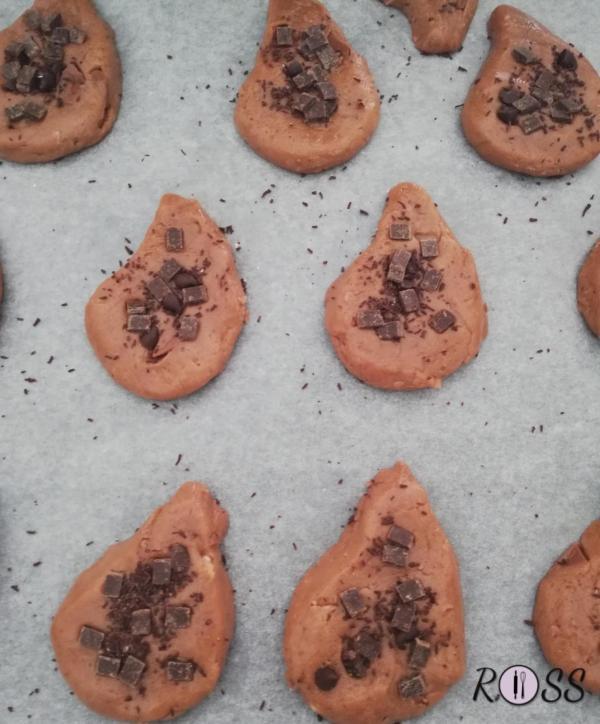 Aggiungete le gocce di cioccolato fondente sulla superficie e ponete i biscotti ottenuti su una teglia, precedentemente ricoperta da carta forno.
Infornate per circa 12 minuti.
