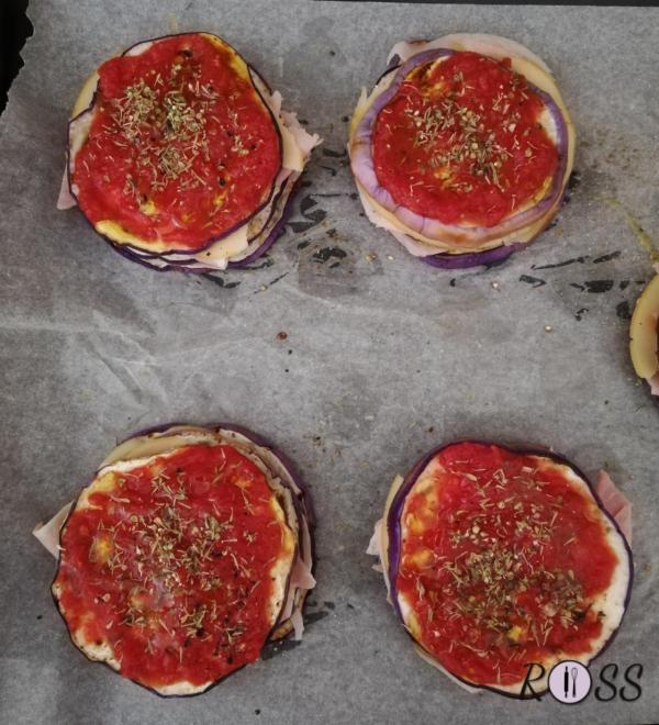 Completate con la passata di pomodoro, precedentemente condita con olio, sale ed origano.
Ponete due cucchiai di passata su ogni torretta. 
Definite con del timo, pepe nero ed un filo d'olio.
Cuocete per 10minuti in forno preriscaldato a 180°, modalità ventilata 