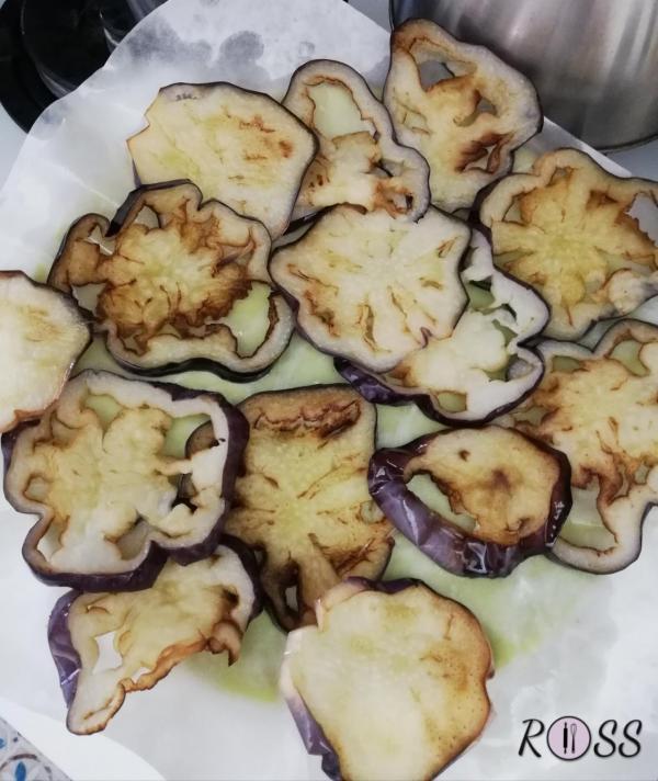 Per prima cosa tagliate a fette rotonde la melanzana e friggetele in padella con abbondante olio bollente. Poggiate le fette fritte su carta assorbente e salatele. 