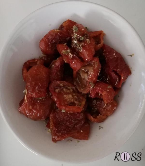 Adesso, in un pentolino, bollite i pomodorini secchi. A fine cottura conditeli con origano e olio
