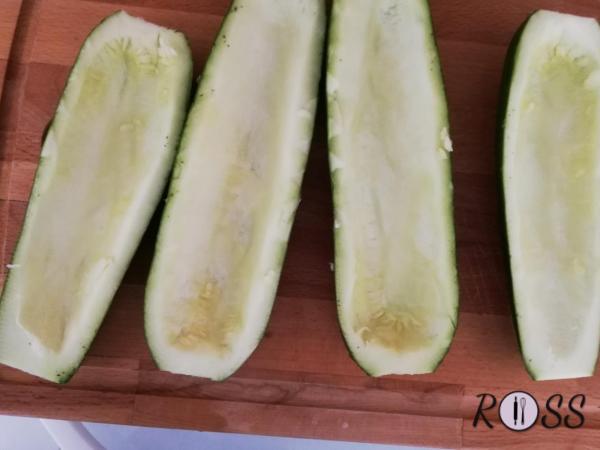 Per prima cosa tagliate a metà, lungo il lato maggiore, le zucchine e svuotatele con un cucchiaio, facendo attenzione a non romperle. 