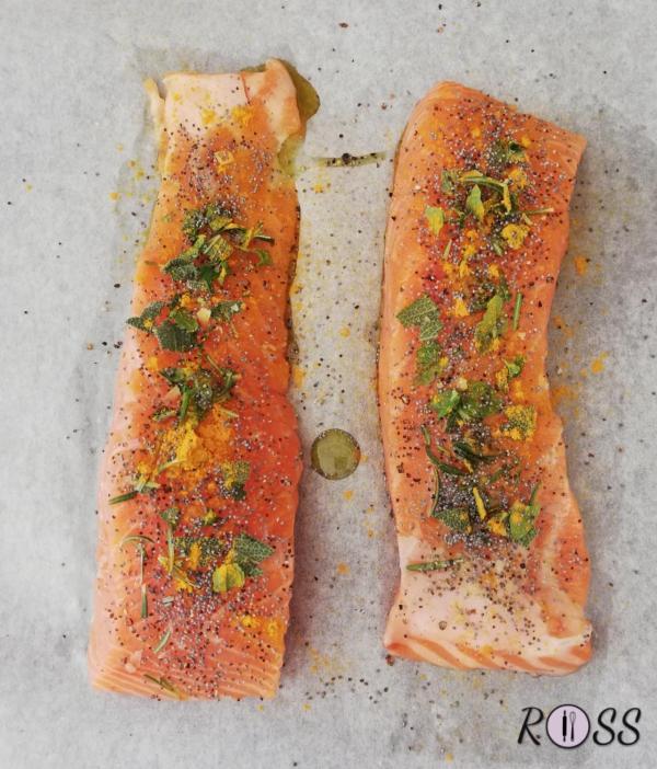 Accendete il forno, modalità ventilata, a 180°C.
Ponete I vostri tranci di salmone sfilettato e privo da qualsiasi spina su una teglia rivestita da carta forno.
Iniziate a tagliuzzate con le mani le varie erbette aromatiche e ponetele sui due tranci.
Adesso aggiungete il pepe nero, la curcuma, sale e l'olio