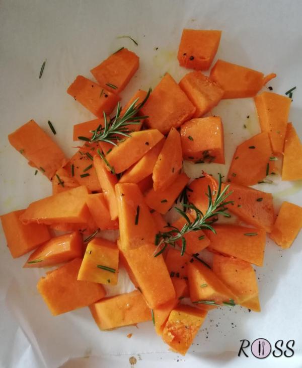 Pulire e tagliate a tocchetti la zucca rossa.
Accendere il forno a 180°C, modalità ventilata e
foderare una teglia con della carta forno e adagiare  la zucca. Condirla con sale, pepe, olio e rosmarino.
Infornare. A metà cottura aggiungere il brodo, infornare ed ultimare la cottura in forno. 
Servire caldo o freddo 