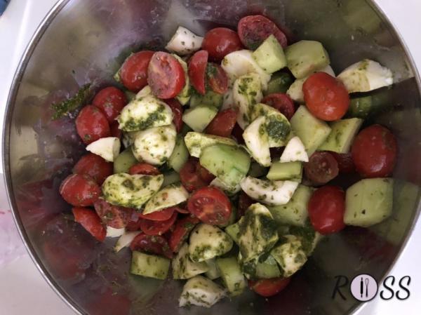 Prepara le verdure e la feta, tagliandole a dadini, amalgamandole con il pesto e le foglie di basilico