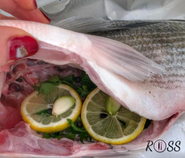 Per prima cosa fai pulite dal tuo pescivendolo di fiducia la “pancia” del tuo pesce, SENZA desquamarlo.
Adesso affetta mezzo limone ed inserisci alcune fette nell’incavatura svuotata, insieme all’aglio, prezzemolo e peperoncino ( se gradisci).
Accendi il forno a 200°C modalità ventilata 