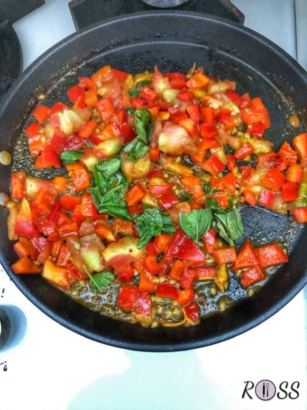 Lava e taglia a piccoli pezzi il mezzo peperone. Scalda una padella, aggiungi un filo d'olio extravergine di oliva, dove farai soffriggere uno spicchio d'aglio, unisci la polpa di pomodoro ed il peperone. Aggiungi menta e basilico tritati. Adesso puoi eliminare lo spicchio d'aglio.