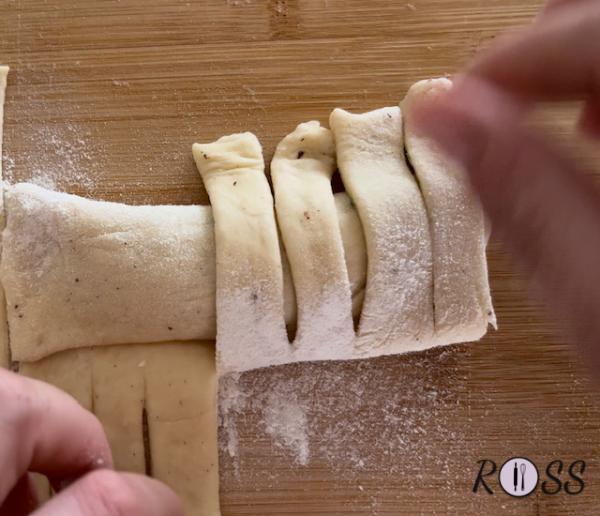 Arrotola fino a chiudere, avendo le frange sulla parte superiore di ogni flauto (vedi foto)